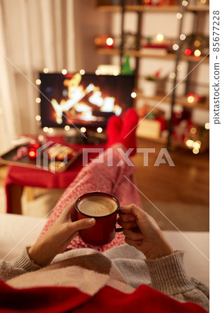 woman watching tv and drinking coffee on christmas 85677228