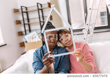 women with ruler in shape of house making faces 85677479