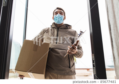 delivery man in mask with parcel box and clipboard 85677481