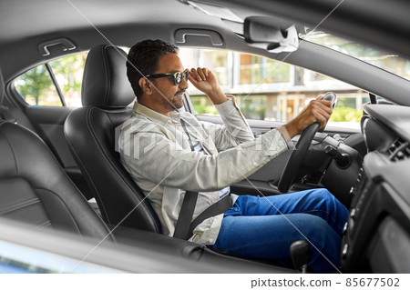 smiling indian man in sunglasses driving car smiling indian man in sunglasses driving car 85677502