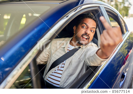 angry man driving car and showing middle finger 85677514