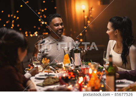 happy friends drinking wine at christmas party 85677526
