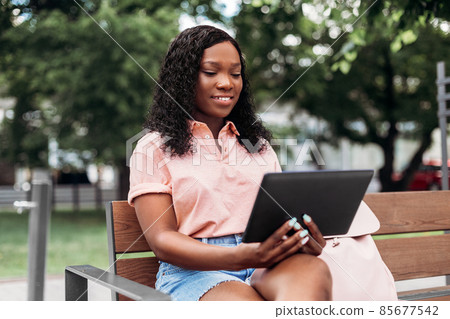 african american woman with tablet pc in city 85677542