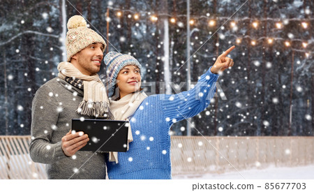 couple in winter clothes with tablet computer 85677703