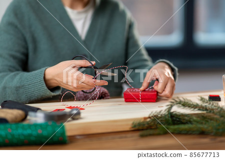 close up of woman packing christmas gift at home close up of woman packing christmas gift at home 85677713