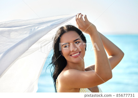woman in bikini swimsuit with cover-up on beach woman in bikini swimsuit with cover-up on beach 85677731