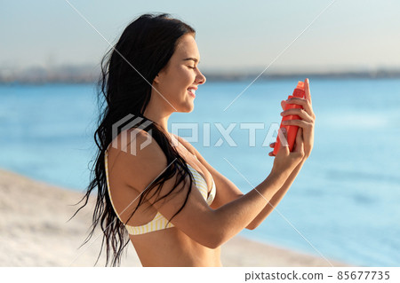 smiling woman in bikini with sunscreen on beach smiling woman in bikini with sunscreen on beach 85677735