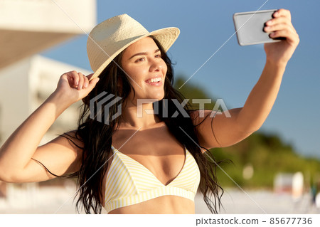 smiling woman in bikini taking selfie on beach smiling woman in bikini taking selfie on beach 85677736