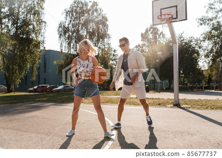 happy couple playing on basketball on playground happy couple playing on basketball on playground 85677737