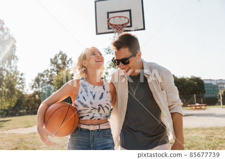 happy couple with ball on basketball playground happy couple with ball on basketball playground 85677739