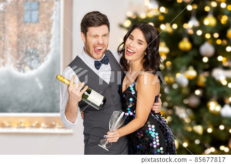 happy couple with champagne at christmas party happy couple with champagne at christmas party 85677817