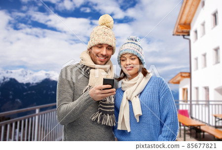 happy couple with smartphone in winter 85677821