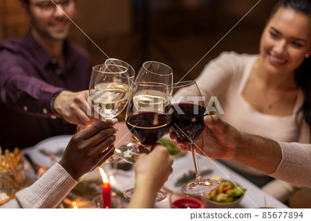 happy friends drinking wine at christmas party happy friends drinking wine at christmas party 85677894