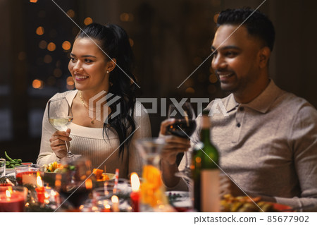 happy friends drinking wine at christmas party happy friends drinking wine at christmas party 85677902