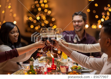 happy friends drinking wine at christmas party happy friends drinking wine at christmas party 85677907