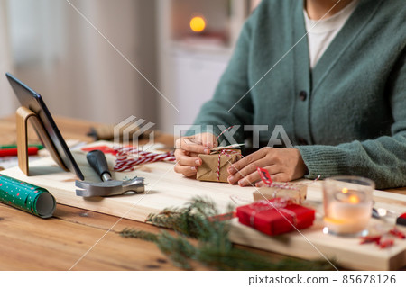 woman with tablet pc packing christmas gift woman with tablet pc packing christmas gift 85678126