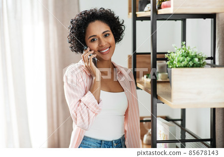 happy smiling woman calling on smartphone at home 85678143