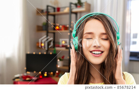 happy young woman with headphones on christmas happy young woman with headphones on christmas 85678214