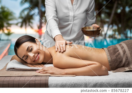 beautiful young woman having salt massage at spa 85678227