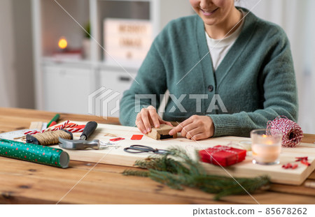 close up of woman packing christmas gift at home close up of woman packing christmas gift at home 85678262