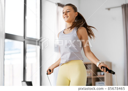 teenage girl exercising with jump rope at home 85678465