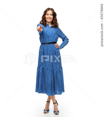 happy young woman in blue dress pointing to camera happy young woman in blue dress pointing to camera 85678668