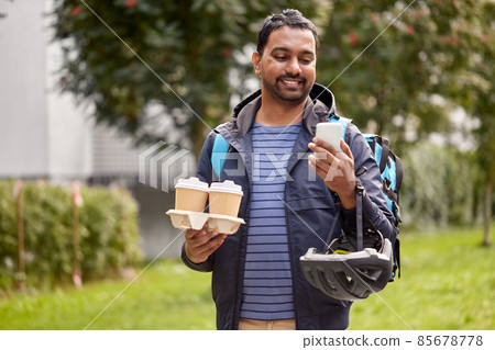 food delivery man with takeaway coffee and phone food delivery man with takeaway coffee and phone 85678778