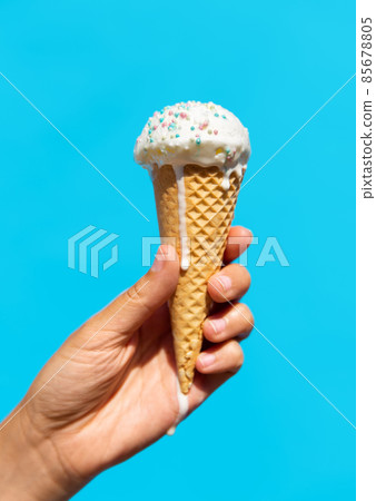 close up of hand holding waffle ice cream cone 85678805