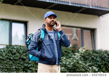 indian delivery man with bag calling on smartphone 85678818