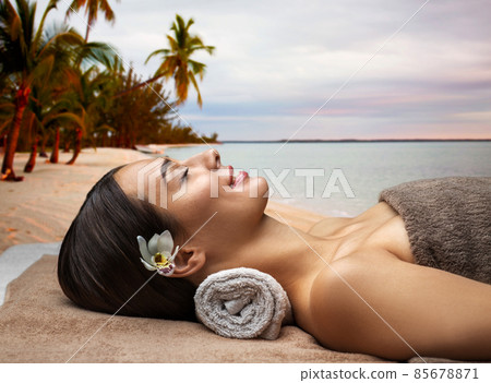 young woman lying at spa over exotic beach young woman lying at spa over exotic beach 85678871