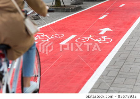 woman cycling along red bike lane road in city woman cycling along red bike lane road in city 85678932