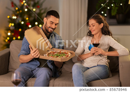 happy couple eating takeaway pizza on christmas happy couple eating takeaway pizza on christmas 85678946