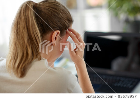 tired woman with laptop having headache at office tired woman with laptop having headache at office 85678957