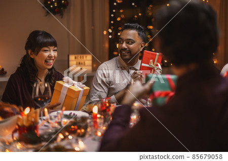 happy friends opening christmas presents at home happy friends opening christmas presents at home 85679058