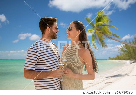 happy couple drinking champagne on exotic beach happy couple drinking champagne on exotic beach 85679089