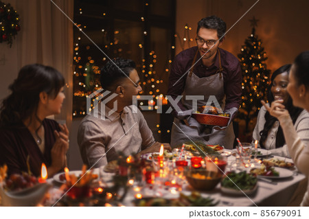 happy friends having christmas dinner at home happy friends having christmas dinner at home 85679091