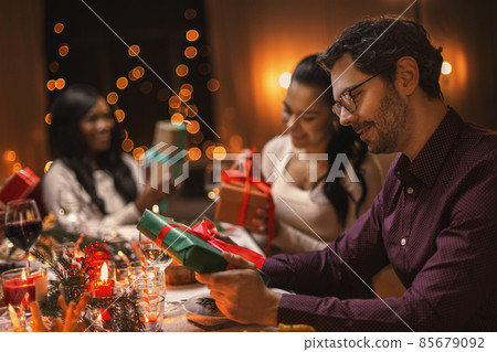happy friends opening christmas presents at home happy friends opening christmas presents at home 85679092