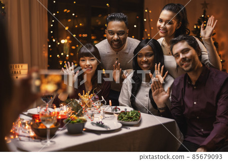 happy friends photographing at christmas dinner happy friends photographing at christmas dinner 85679093