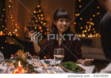 happy woman drinking red wine at christmas party happy woman drinking red wine at christmas party 85679094