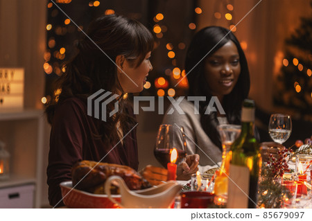 happy women having christmas dinner at home happy women having christmas dinner at home 85679097