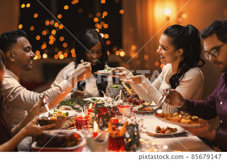 happy friends having christmas dinner at home happy friends having christmas dinner at home 85679147
