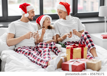 happy family eating coookies in bed on christmas happy family eating coookies in bed on christmas 85679171