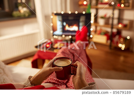 woman watching tv and drinking coffee on christmas 85679189