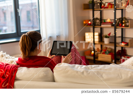 woman with tablet computer at home on christmas woman with tablet computer at home on christmas 85679244
