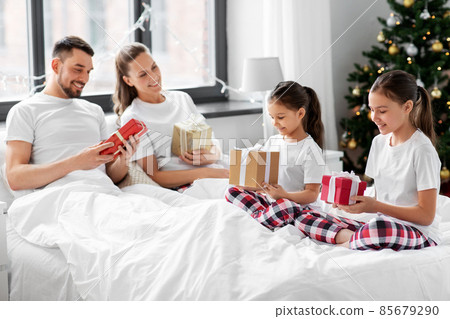 happy family with christmas gifts in bed at home 85679290