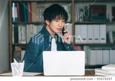 一個男人在工作中打智能手機電話 85679397