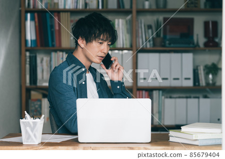 A man making a smartphone call at work A man making a smartphone call at work 85679404