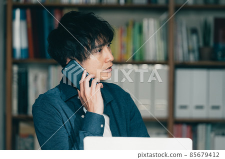 一個男人在工作中打智能手機電話 一個男人在工作中打智能手機電話 85679412