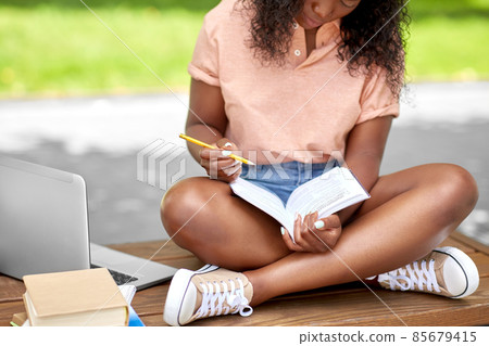 african american student girl making notes in book african american student girl making notes in book 85679415