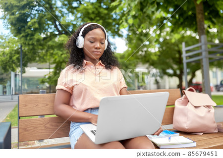 african student girl in headphones with laptop 85679451